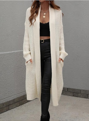 Mulher com cardigan longo creme, top preto e calças justas em pele preta, look elegante e moderno ideal para o outono e inverno.
