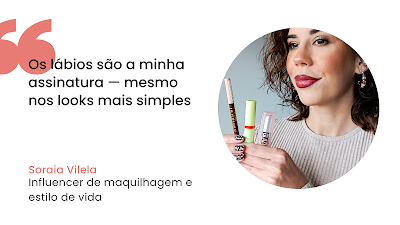 Gráfico digital com fundo branco contendo uma citação e uma fotografia. À esquerda, aspas grandes em coral e o texto em preto: "Os lábios são a minha assinatura — mesmo nos looks mais simples". Abaixo, o nome "Soraia Vilela" em coral e a sua ocupação em preto. À direita, numa moldura circular, Soraia Vilela sorri ligeiramente, exibindo lábios pintados num tom de vermelho escuro brilhante. Ela segura três produtos de maquilhagem (lápis e batons) e mostra as unhas com uma "nail art" de padrão axadrezado em preto e branco. Ela usa uma camisola de malha bege e brincos de argola com pedras.