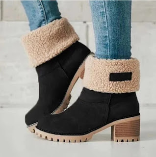 Botas de inverno: conforto e estilo num só passo Par de botas de inverno pretas com interior de pelo bege, combinadas com calças de ganga, ideais para dias frios e looks confortáveis de outono.