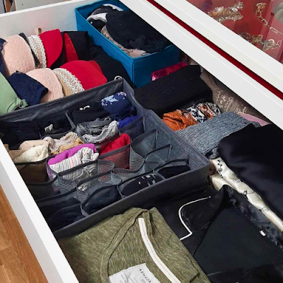 Gaveta com roupa interior, meias e peças do dia-a-dia organizadas em colmeias e caixas, mostrando uma solução prática de arrumação para o closet.