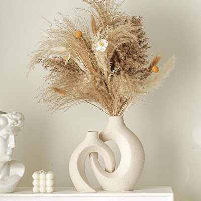 Jarras escultóricas em cerâmica clara com arranjo de flores secas e gramíneas naturais, criando uma decoração primaveril minimalista, elegante e inspirada na natureza.