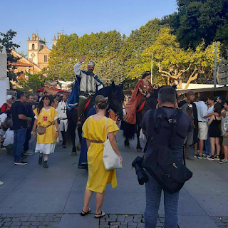 Figuras reais a cavalo desfilam entre a multidão durante a Feira Medieval de Santa Maria da Feira 2024, recriando a corte portuguesa do século XV.